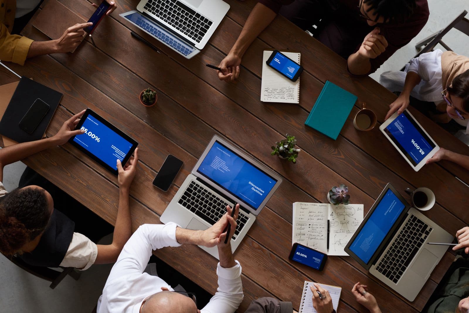 Equipe diversa analisando dados em laptops e tablets sobre uma mesa